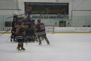 Goffstown celebrates their 4-3 overtime winner. The goal was scored by Captain, Nick Nault. (Photo by Charron)